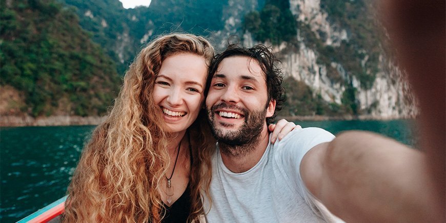 Mann und Frau machen ein Selfie auf einem Boot im Khao Sok National Park