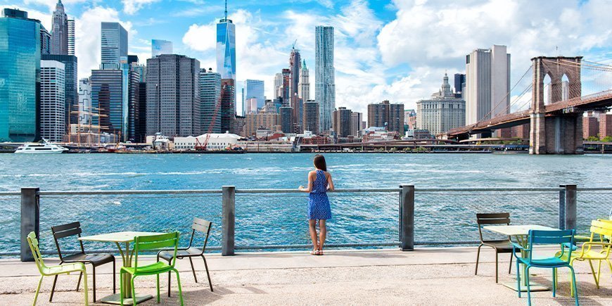 Frauen in Sommerkleidern mit Blick auf die Skyline von New York