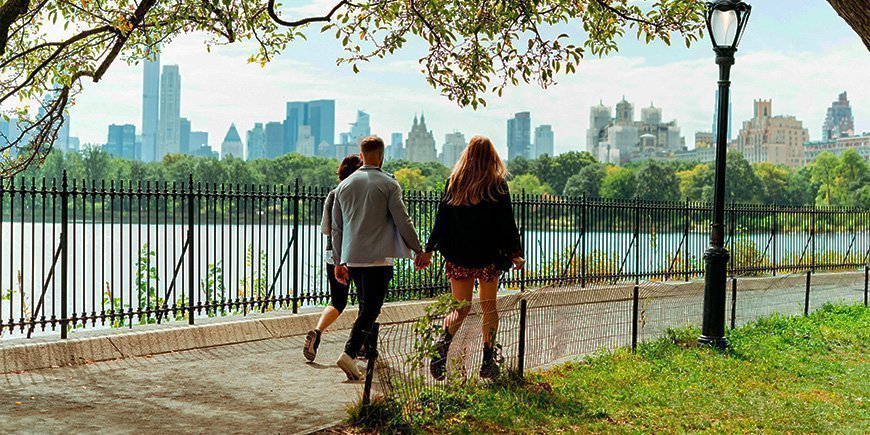 Paar beim Spaziergang Hand in Hand bei sonnigem Wetter im Central Park, New York City