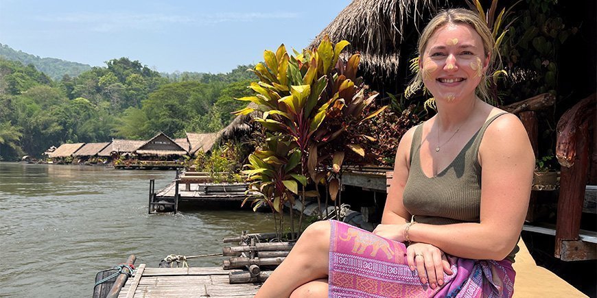 Cecilie von TourCompass auf einer Bank am River Kwai