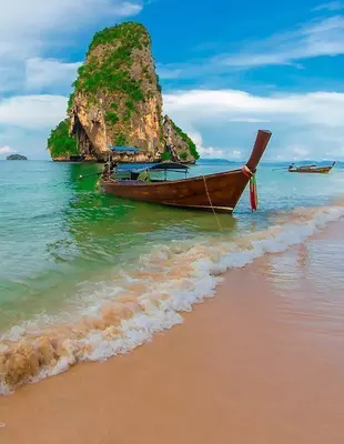 Longtail-Boote unter blauem Himmel am Strand von Krabi, Thailand