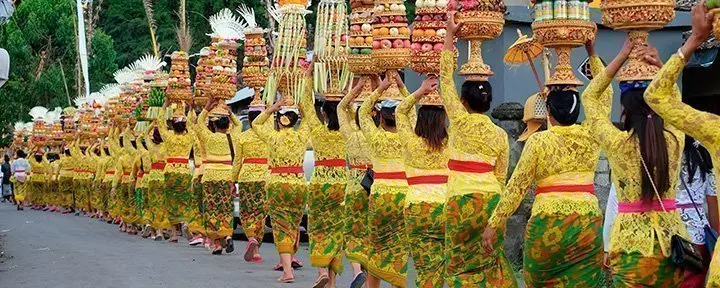 Umzug mit wunderschönen balinesischen Frauen in traditioneller Kleidung, auf dem Weg zu einer hinduistischen Zeremonie auf Bali.