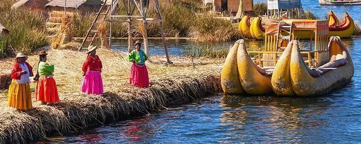Peruanische Frauen in traditioneller Kleidung heißen Touristen auf Uros Island willkommen